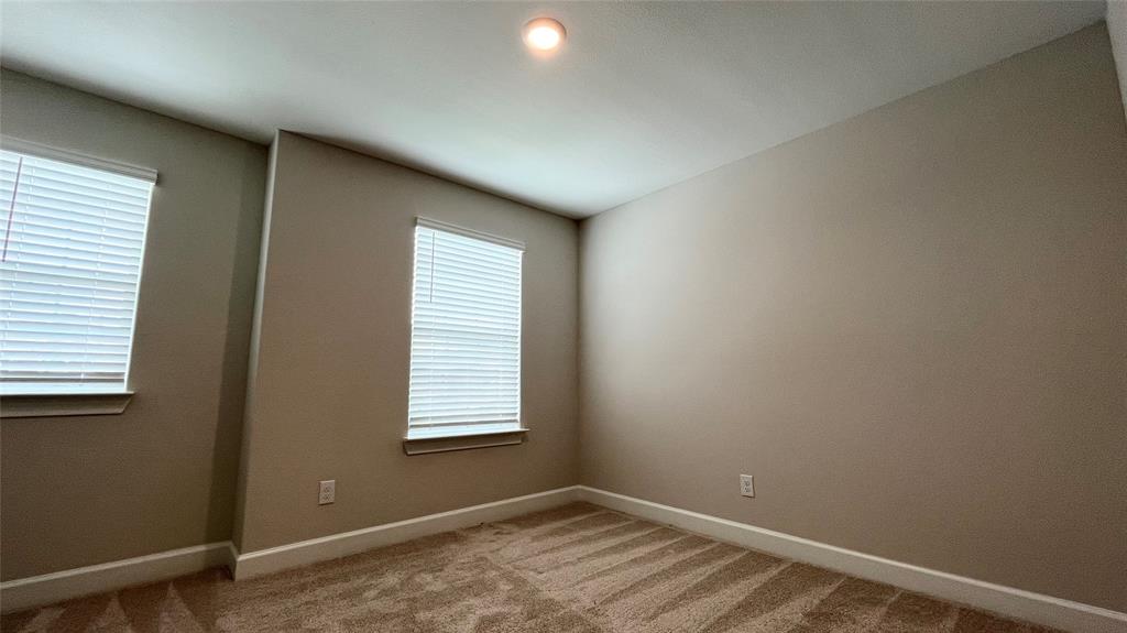 Wall-to-wall carpeting, dual windows with blinds, recessed ceiling light, and neutral wall tones