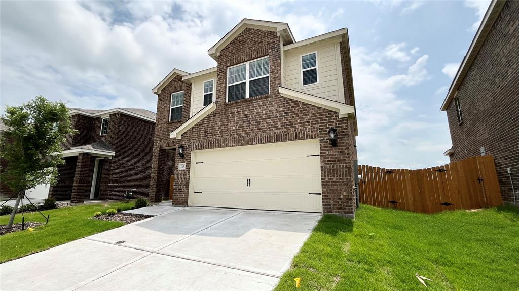 Two-story residence featuring a brick and siding exterior, an attached two-car garage, and a concrete driveway