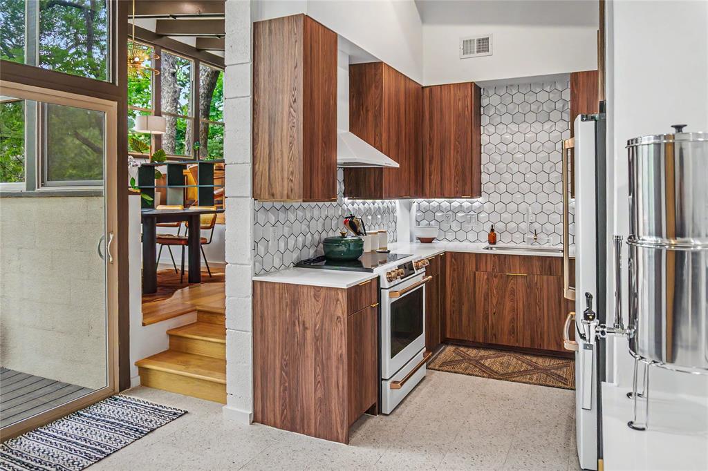Kitchen featuring custom cabinetry, designer tile backsplash, and GE Café appliance package