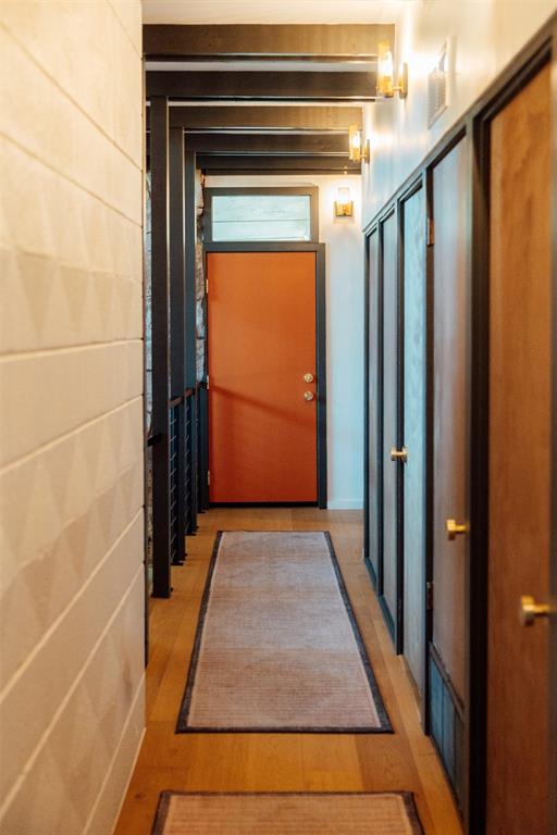 Entry hall with brass sconces, geometric wall, and custom 34" orange front door