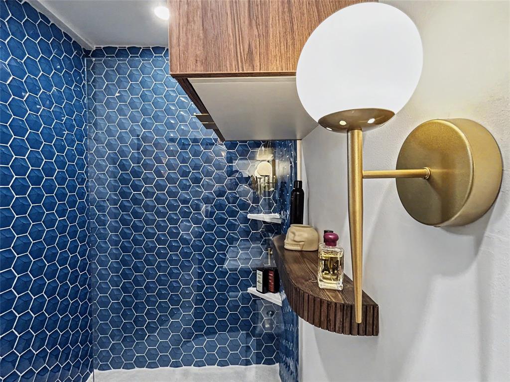 Primary en-suite bath featuring blue hex tile and statement sconces