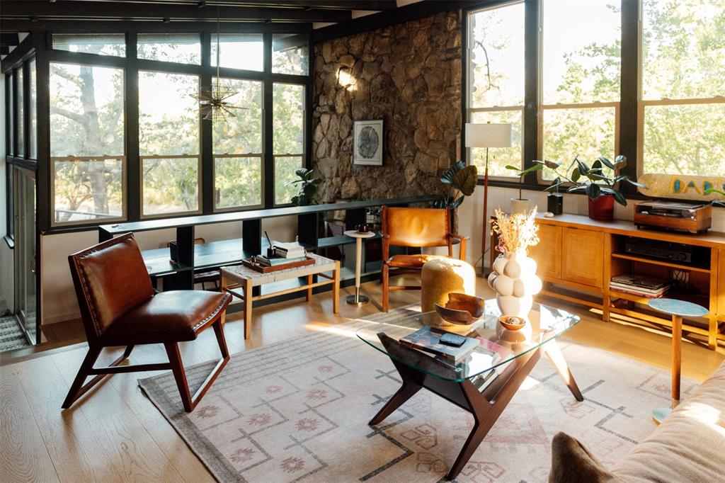 Rock wall, starburst chandelier, and treetop views in the main living room Rock wall, starburst chandelier, and treetop views in the main living room