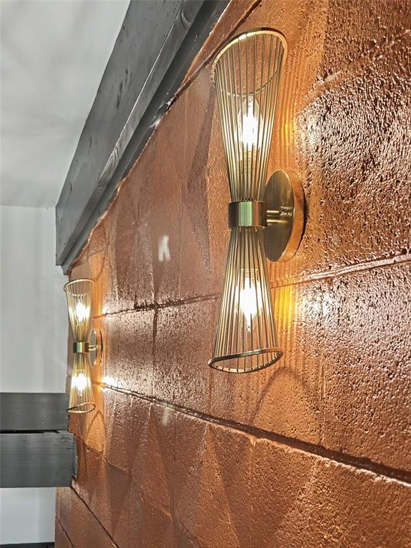 Brass sconces glowing on the mid-century textured orange wall