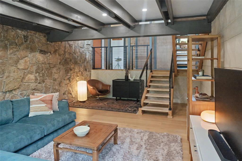 Lower-level living room featuring a reading nook, laundry room, and anchored by MCM rock wall