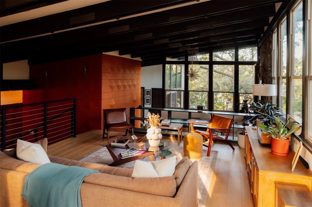 Orange block wall, dark beams, and cable rail in the main living room Orange block wall, dark beams, and cable rail in the main living room