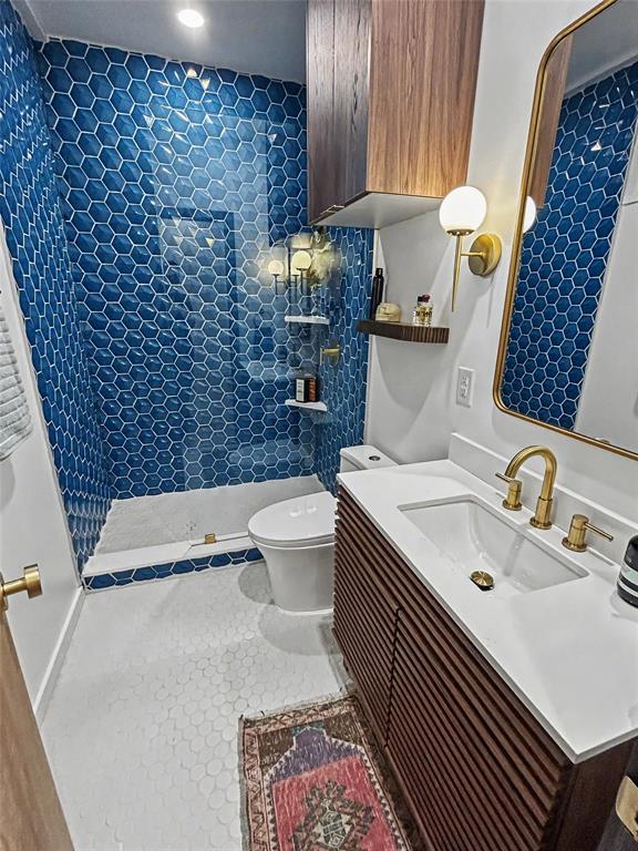 Primary en-suite bath with blue hex tile and slatted wood vanity