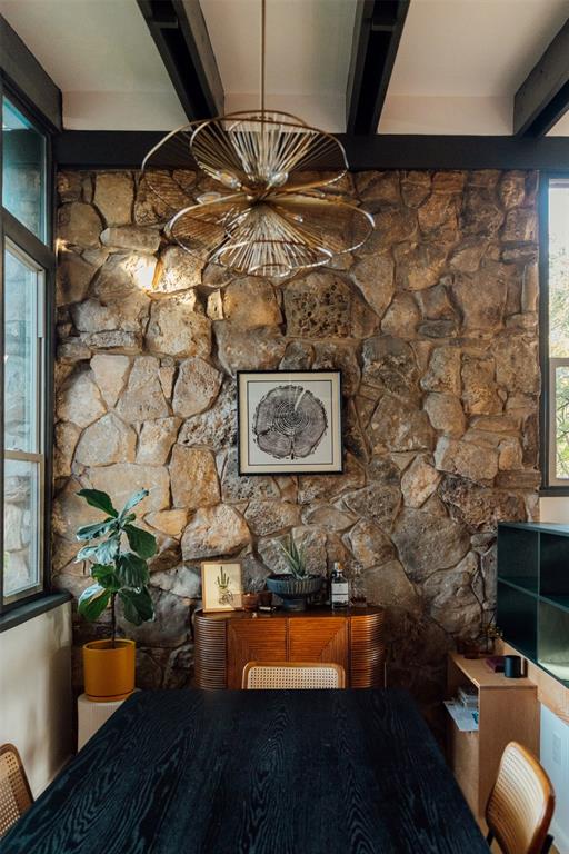 Dining room a half level up, with stone wall and brass chandelier Dining room a half level up, with stone wall and brass chandelier