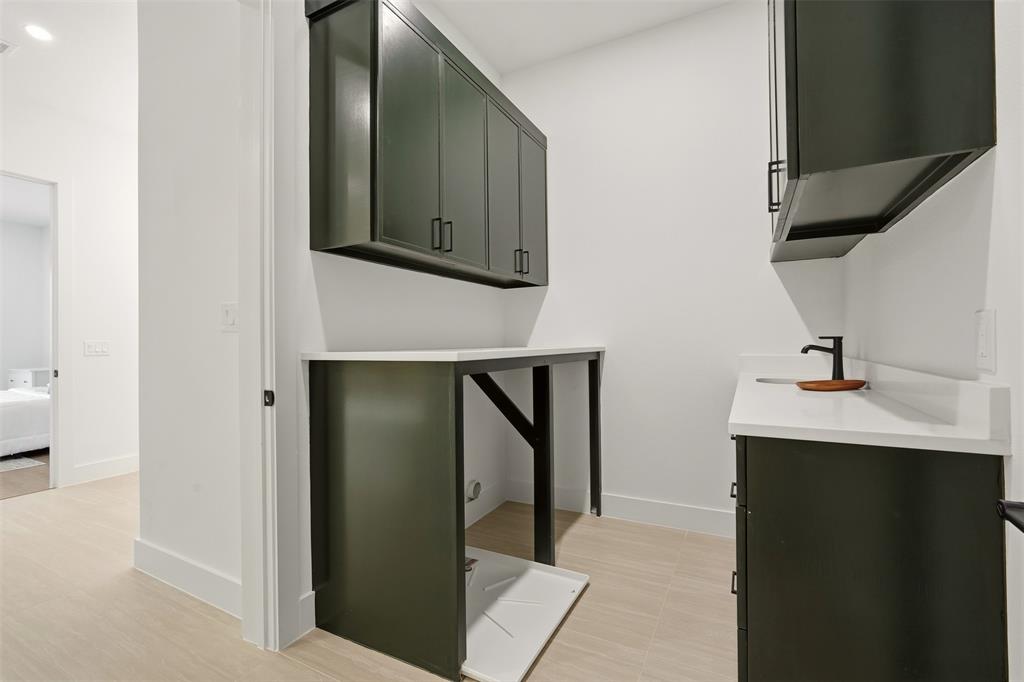 Dark-toned cabinetry with matte black hardware, white countertops, and a black faucet