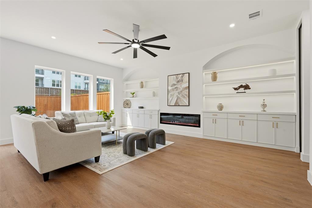 Wood-finish flooring, recessed lighting, and a modern ceiling fan Wood-finish flooring, recessed lighting, and a modern ceiling fan