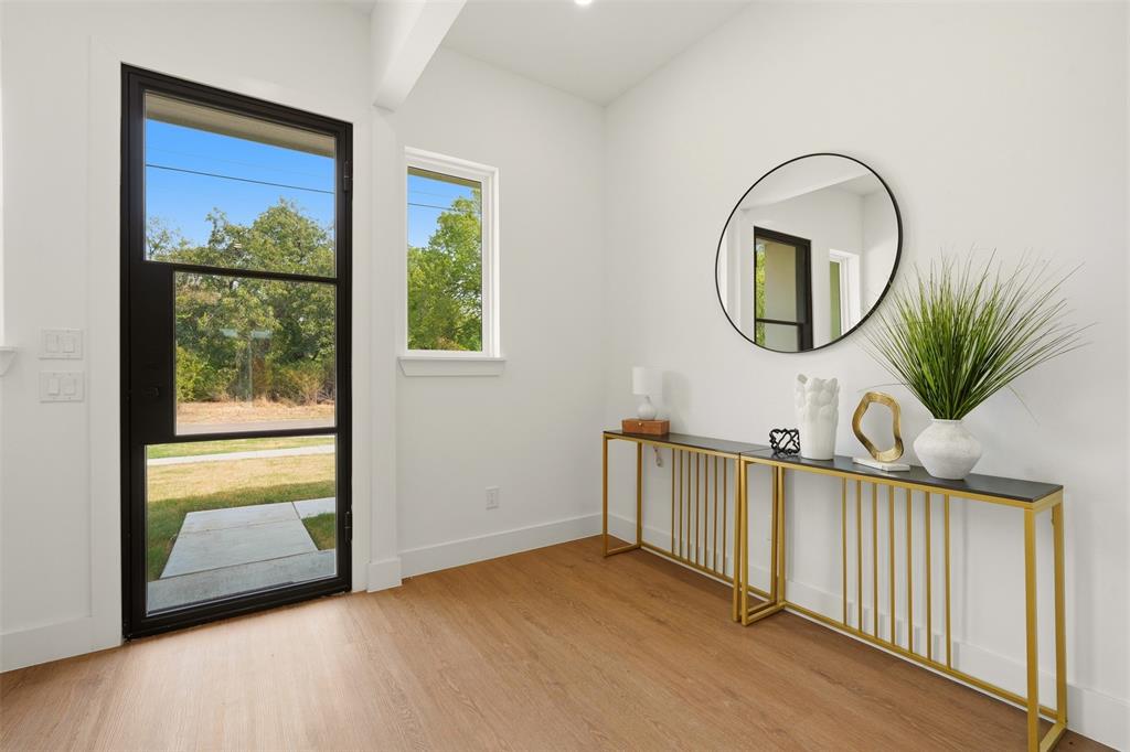 Wood-finish flooring, white walls, and a black-framed glass entry door Wood-finish flooring, white walls, and a black-framed glass entry door