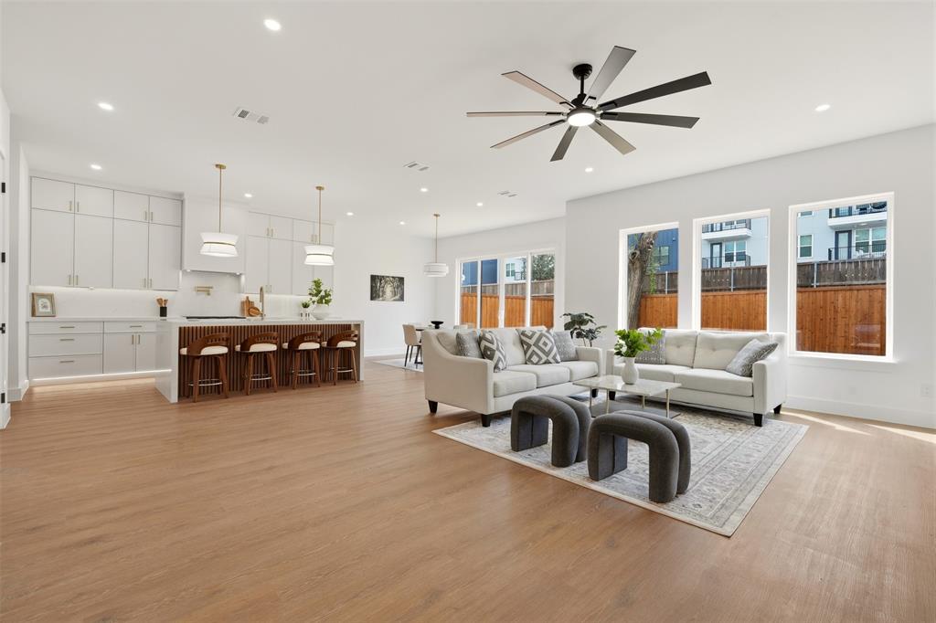 Open-concept living space featuring wood-finish flooring, recessed lighting, and a contemporary ceiling fan Open-concept living space featuring wood-finish flooring, recessed lighting, and a contemporary ceiling fan