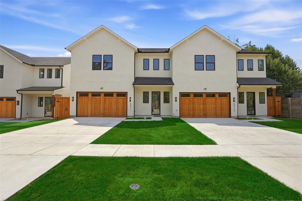 Contemporary townhome exterior with light-toned stucco siding and dark-trimmed windows