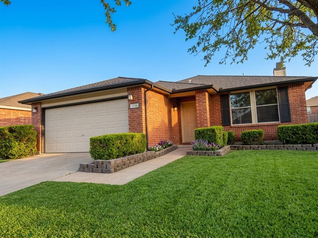 Brick exterior with black shutters and an attached garage, staged grass and trees leaves Brick exterior with black shutters and an attached garage, staged grass and trees leaves