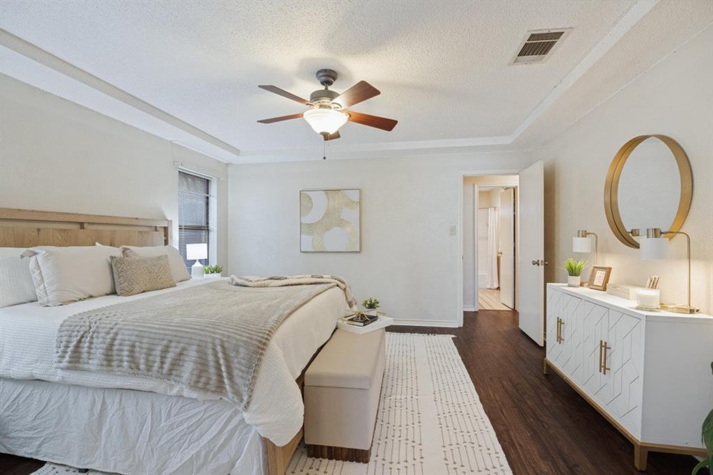 The primary bedroom is nice and bright with laminate flooring, and a ceiling fan.
