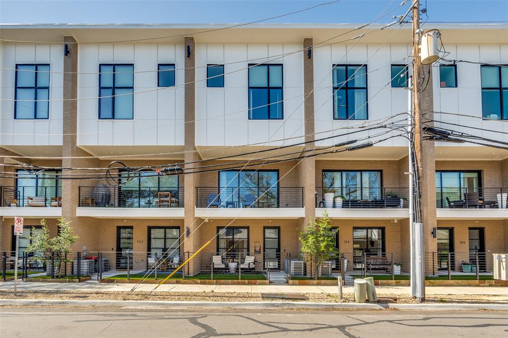 Modern townhome architecture featuring multiple balconies, large windows, and a stucco and panel exterior