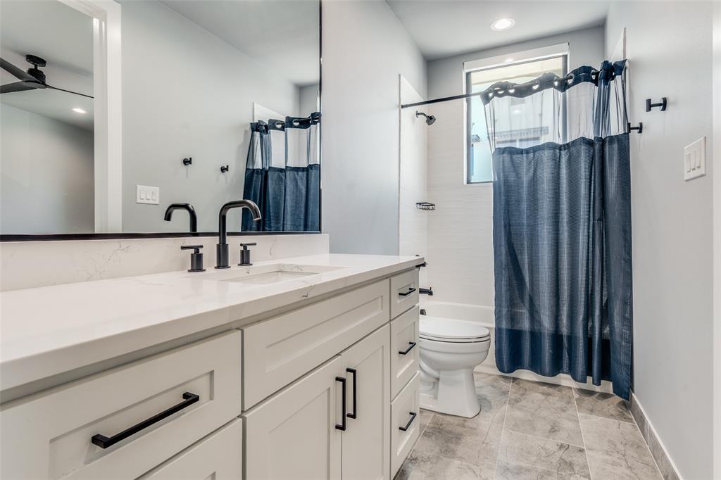 White vanity with shaker-style cabinetry, matte black hardware, and a white countertop
