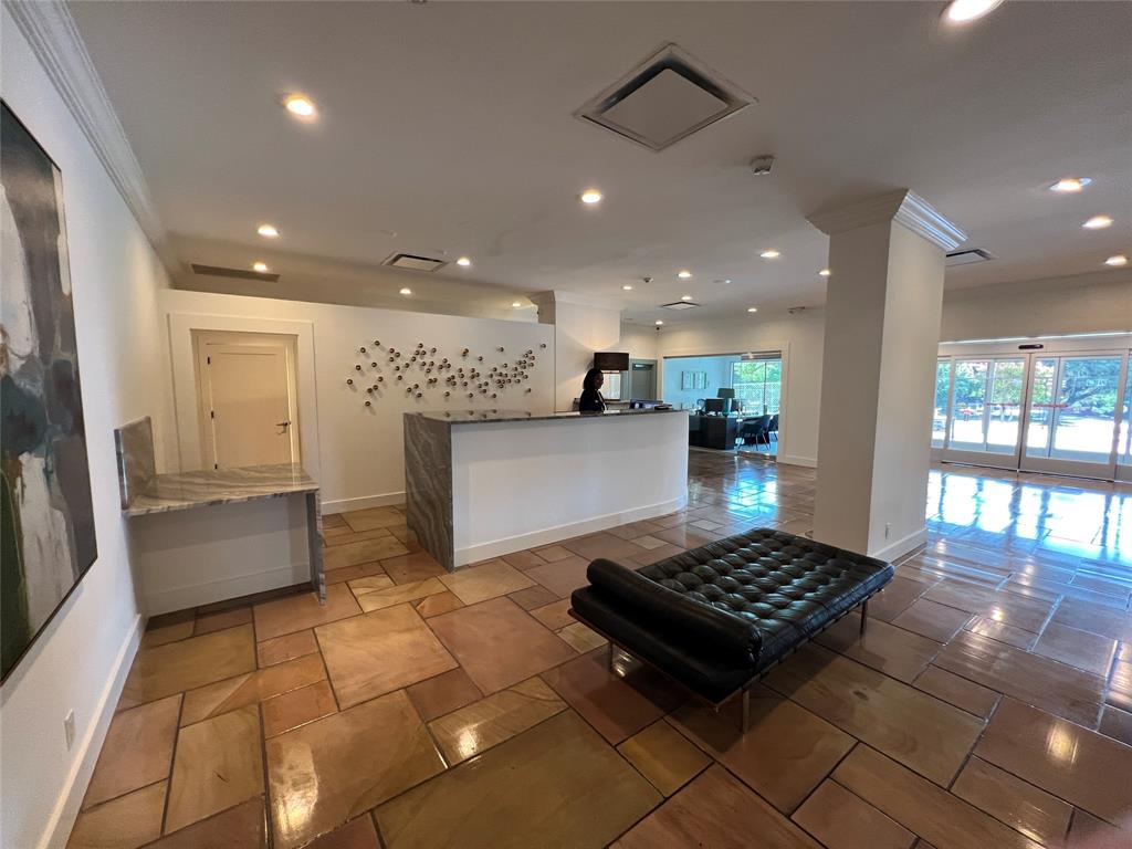 Spacious interior with irregular flagstone flooring, a stone-clad reception desk, and recessed lighting