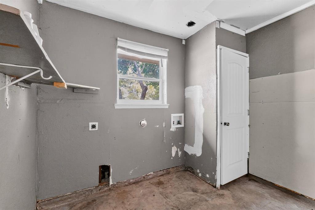 Garage featuring a single-hung window, a white arched-panel door, and wall-mounted shelving