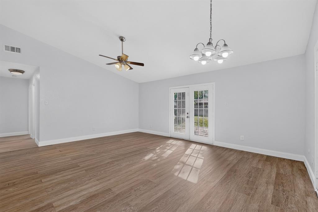 Vaulted ceilings, wood-finish flooring, multi-light chandelier, ceiling fan, and French doors Vaulted ceilings, wood-finish flooring, multi-light chandelier, ceiling fan, and French doors