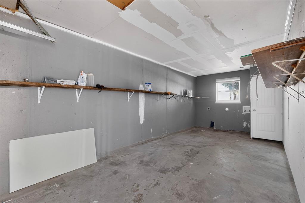 Garage featuring a single-hung window and wall-mounted shelving