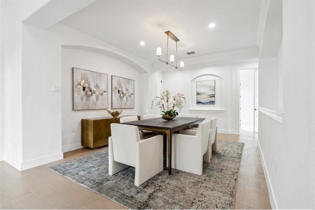 Recessed ceiling lighting, wood-finish flooring, and a modern linear chandelier Recessed ceiling lighting, wood-finish flooring, and a modern linear chandelier