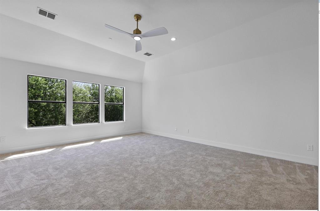 Vaulted ceiling, recessed lighting, ceiling fan, three windows, and carpeted flooring