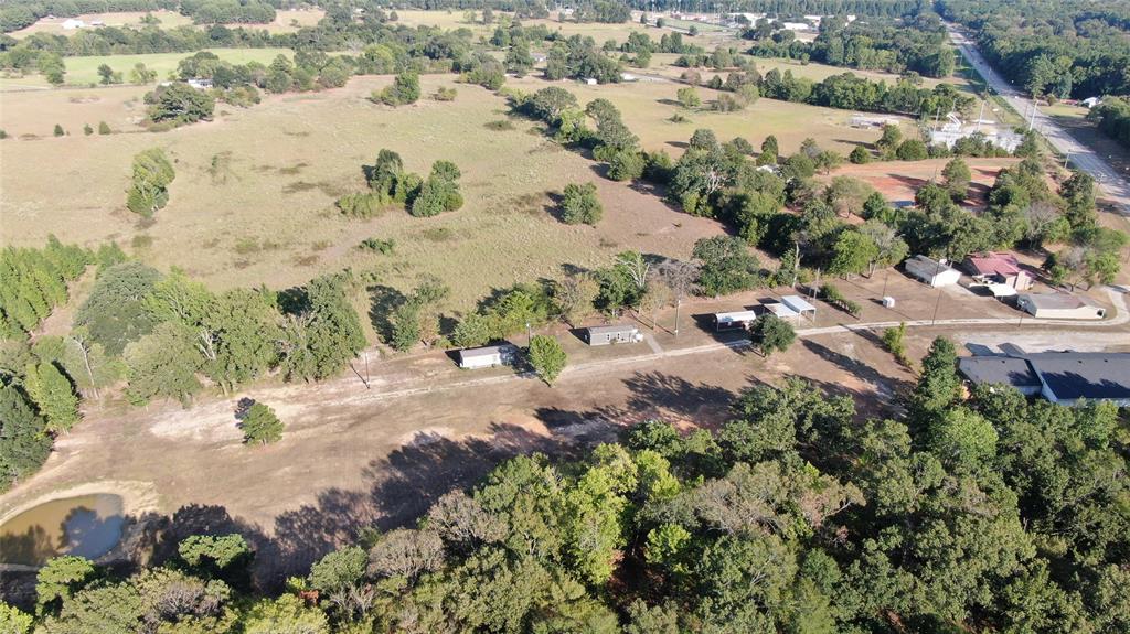 Expansive open fields, multiple mature trees, and a visible pond