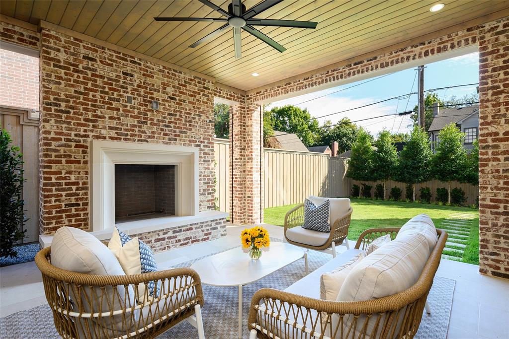 Rear loggia with large limestone slab flooring, Isokern wood-burning fireplace with raised hearth and cast stone surround, and automated screens