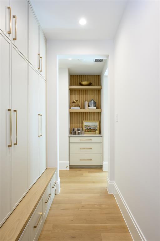 Mudroom with floor-to-ceiling locker-style cabinetry, key drop with floating shelves and reeded accent material