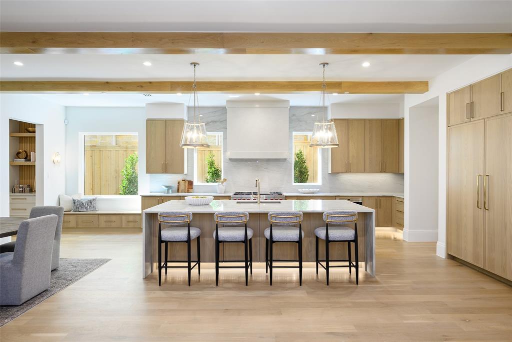 Gourmet culinary kitchen with custom slim Shaker, white oak cabinetry with soft-close doors and drawers, natural stone countertops with waterfall detail at island