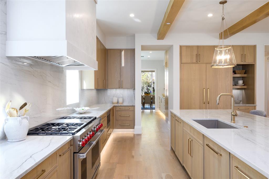 Gourmet culinary kitchen with custom slim Shaker, white oak cabinetry with soft-close doors and drawers, natural stone countertops with waterfall detail at island