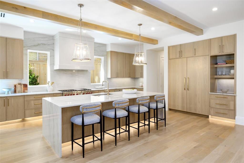 Gourmet culinary kitchen with custom slim Shaker, white oak cabinetry with soft-close doors and drawers, natural stone countertops with waterfall detail at island