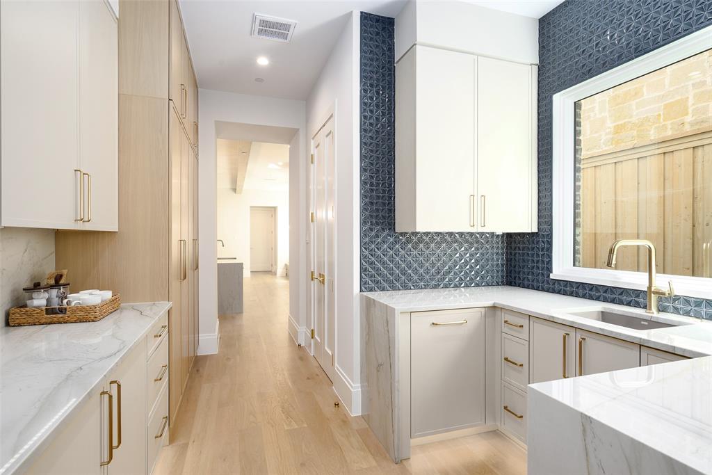 Prep Kitchen/Butler’s Pantry with sink, beverage center, undercounter trash, abundant custom cabinetry and walk-in pantry