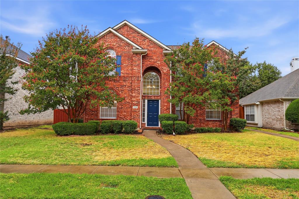 Brick exterior featuring a gabled roofline, arched window, and a dark blue entry door