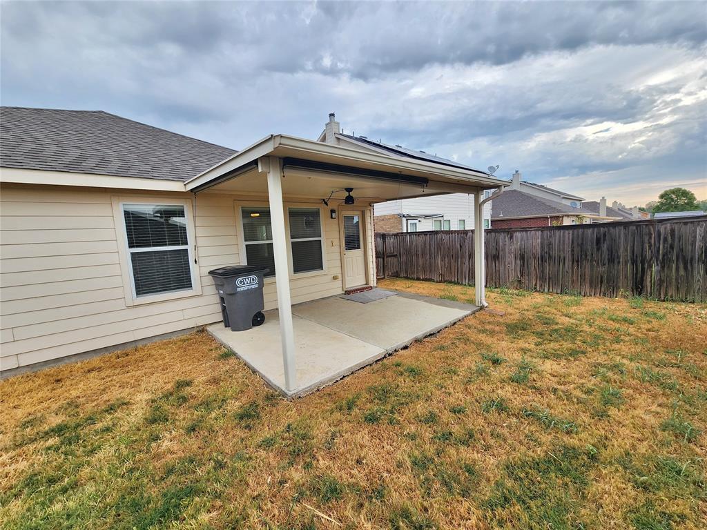 Covered patio with concrete slab, wood-paneled fence, and neutral siding
