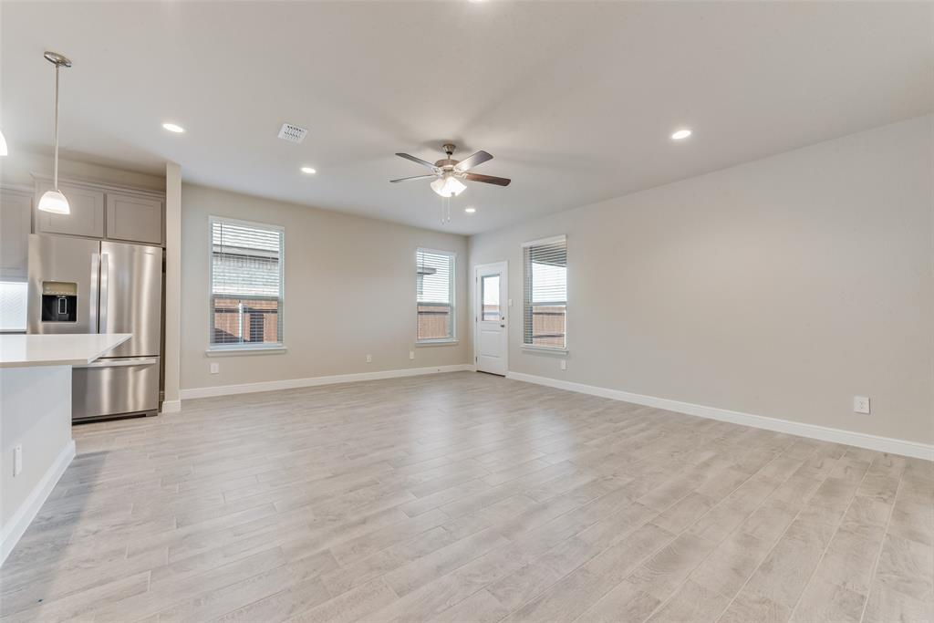 Unfurnished living room with ceiling fan and light hardwood / wood-style flooring