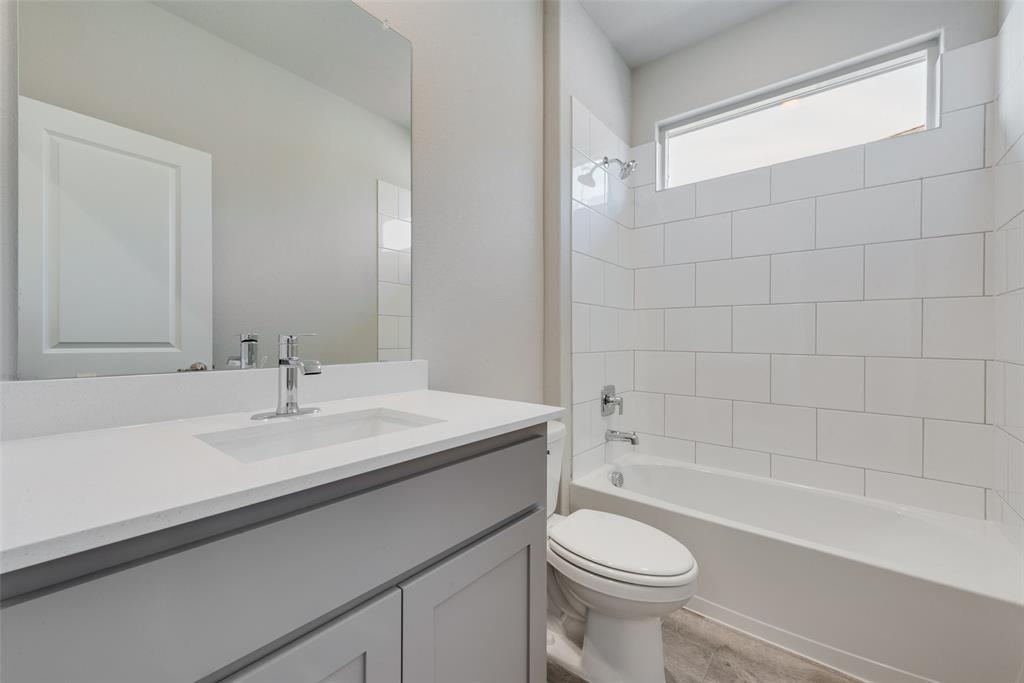 Full bathroom with vanity, toilet, and tiled shower / bath combo