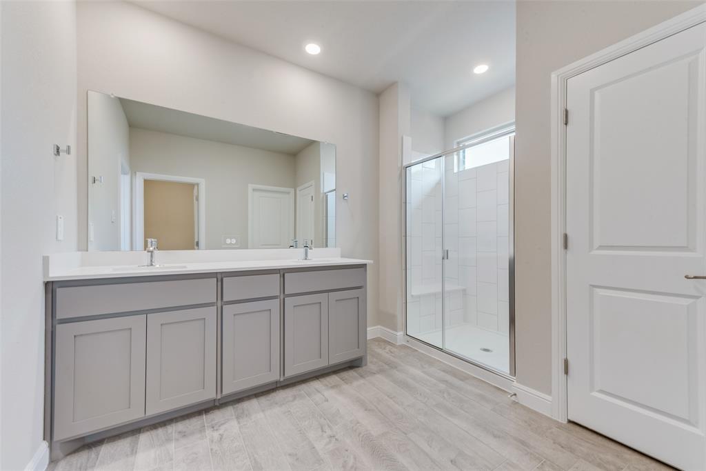 Bathroom with vanity, an enclosed shower, and wood-type flooring