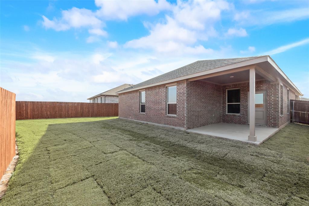 Rear view of property featuring a patio and a lawn