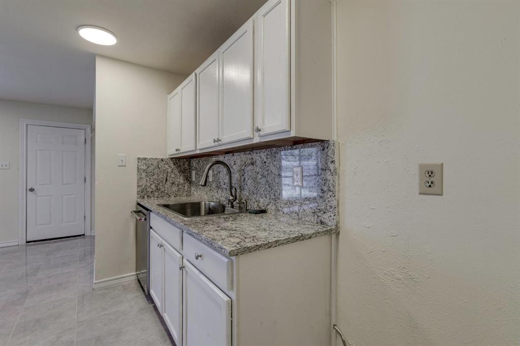 White cabinetry featuring Granite countertops, stainless steel sink with high-arc faucet, and tiled flooring