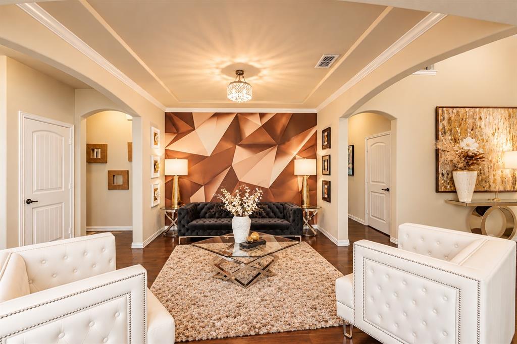 Elegant formal living area showcasing coffered ceiling detail with recessed lighting, white-painted architectural trim, and dual upholstered seating Elegant formal living area showcasing coffered ceiling detail with recessed lighting, white-painted architectural trim, and dual upholstered seating