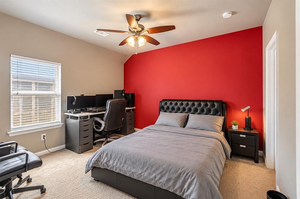 Carpeted room featuring a ceiling fan, window with blinds, and a two-tone wall treatment