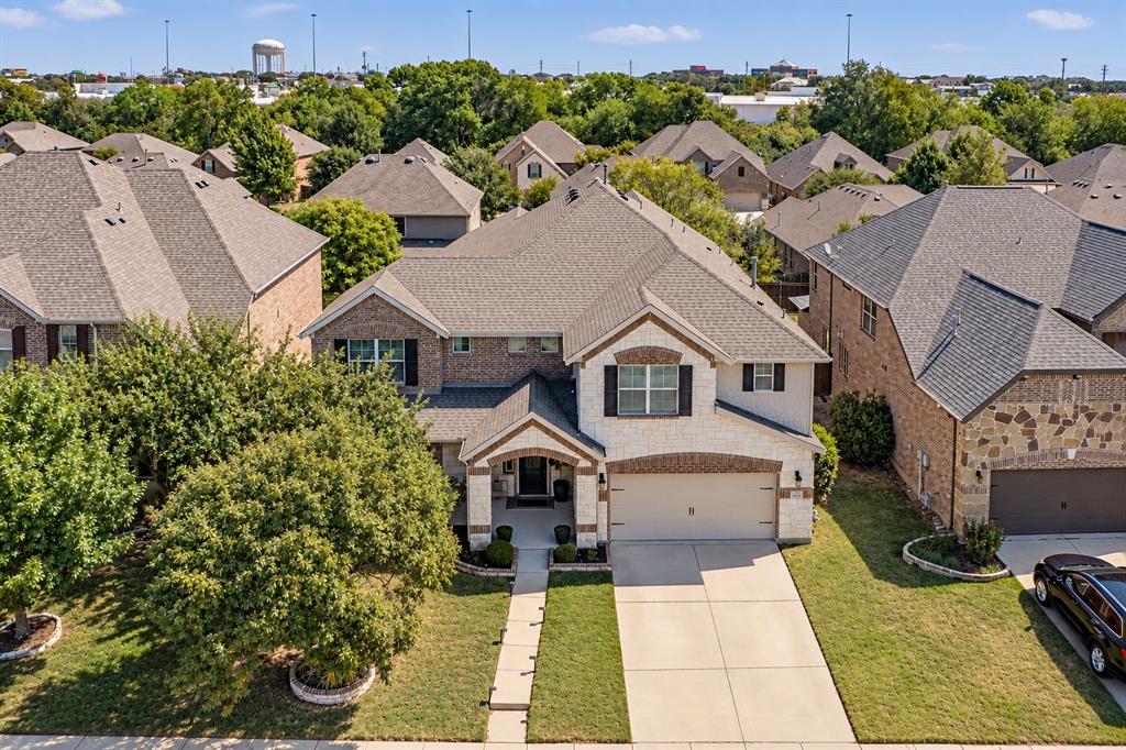Stone and brick façade with a covered entry, attached garage, concrete driveway, and established landscaping Stone and brick façade with a covered entry, attached garage, concrete driveway, and established landscaping