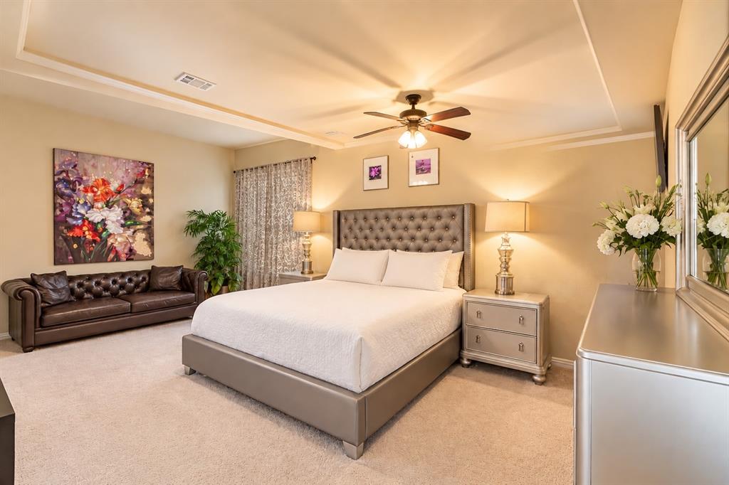 Tray ceiling with integrated lighting, recessed lighting, ceiling fan, and carpeted flooring