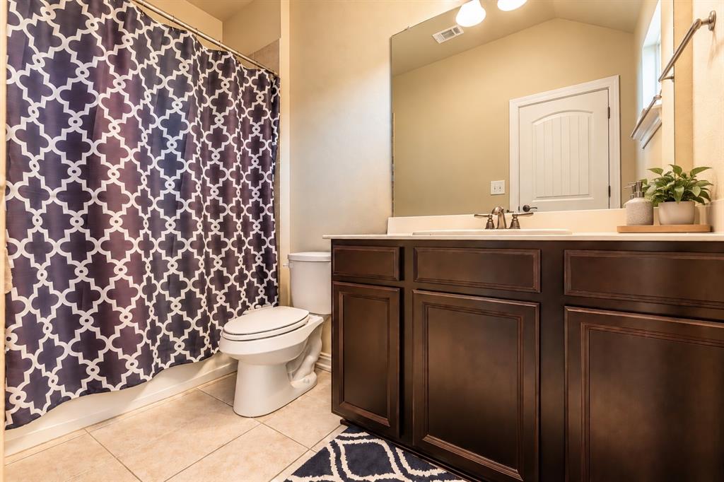Full vanity with dark wood-finish cabinetry, integrated sink, and brushed nickel faucet