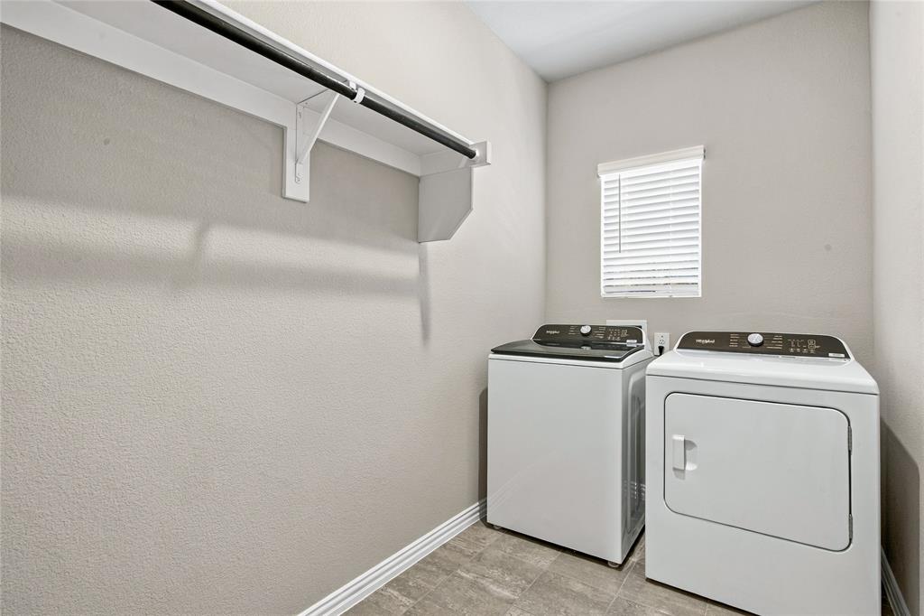 White shelving with a dark-finish hanging rod, neutral-toned walls, and wood-finish flooring