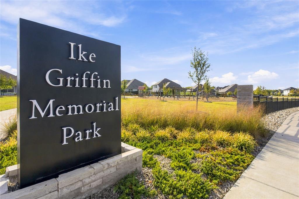 Black monument sign with "Ike Griffin Memorial Park" lettering, stone base, concrete pathway, and landscaped grounds with grass and plantings