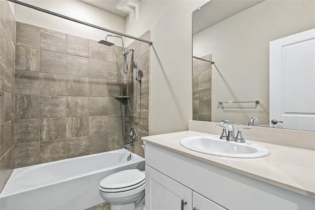 Modern bathroom featuring a ceramic vessel sink with chrome faucet and widespread handles, white vanity cabinetry with ample storage, frameless glass shower enclosure, subway tile surround in neutral tones, and an integrated bathtub-shower combination with chrome fixtures