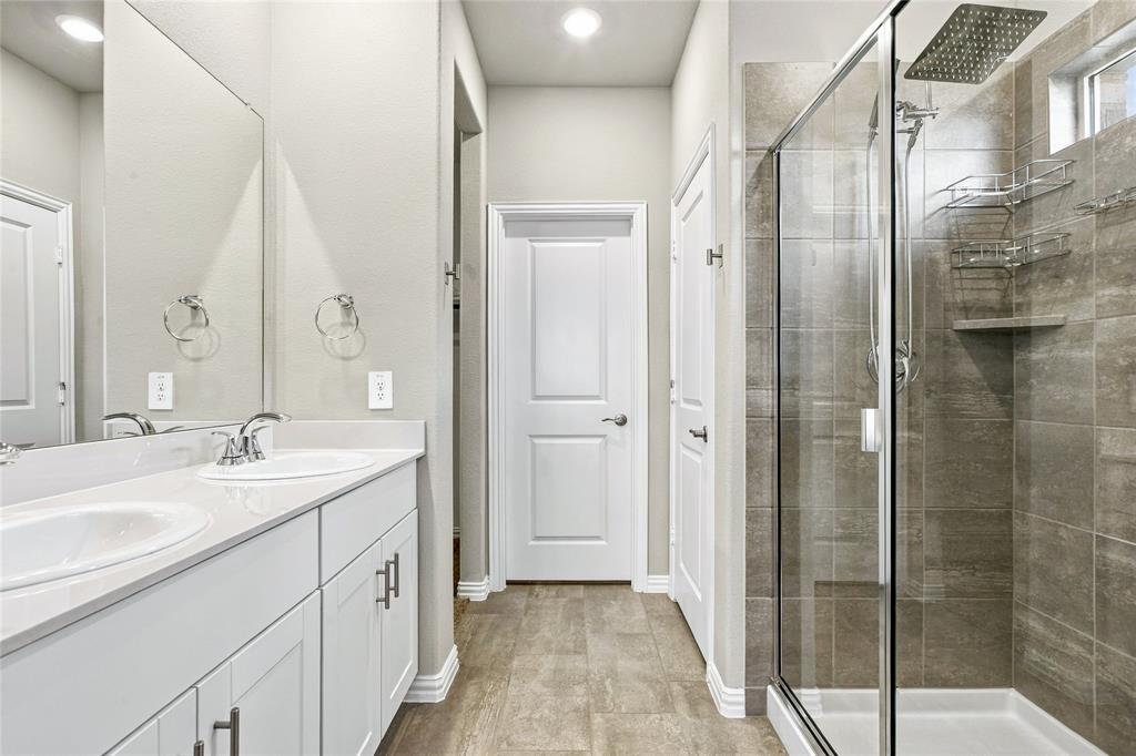 Dual vanity with white cabinetry, quartz-finish countertop, and chrome fixtures