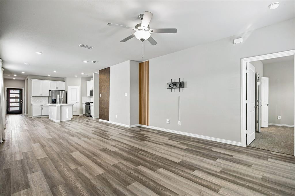 Open-concept room featuring wood-finish flooring, recessed lighting, and a ceiling fan